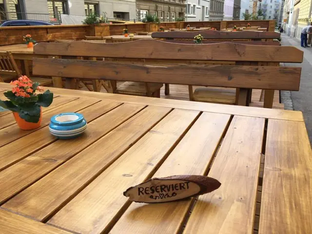 Holztisch im Gastgarten mit einem geschnitzten Reserviert-Schild
